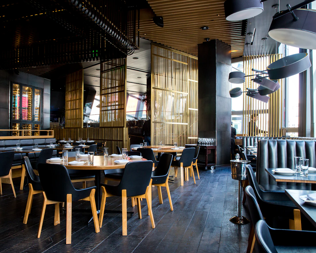 The dim, warm dining room with wooden tables